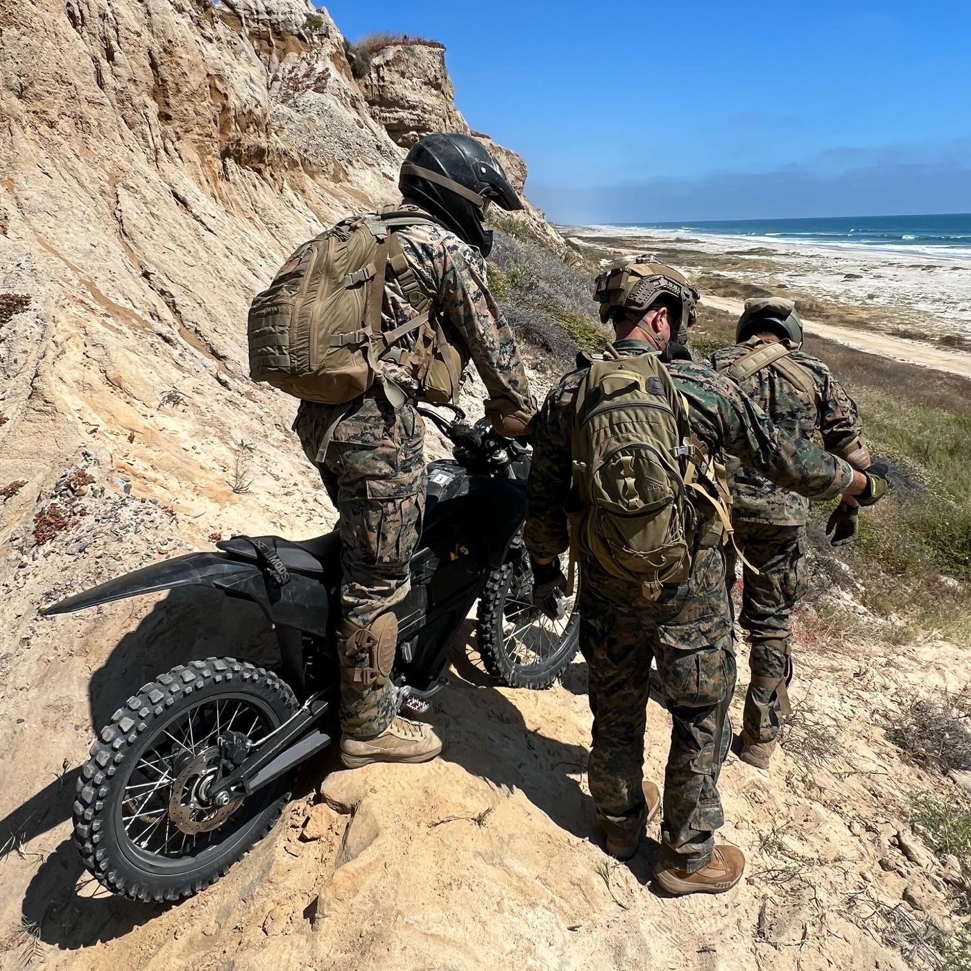 Marines with an electric motorcycle during coastal training