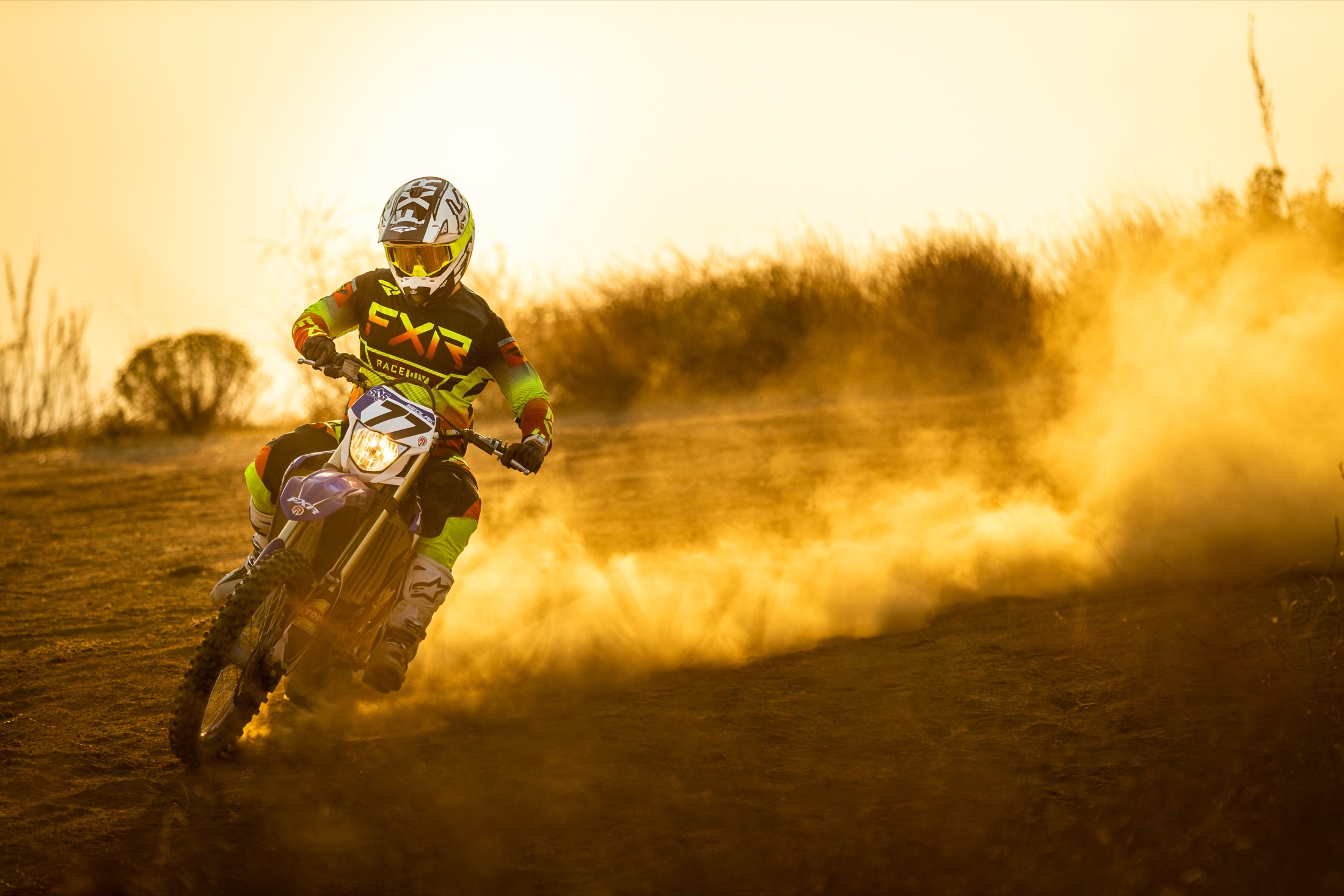 Daniel Sedlak riding through a cloud of golden dust at sunset